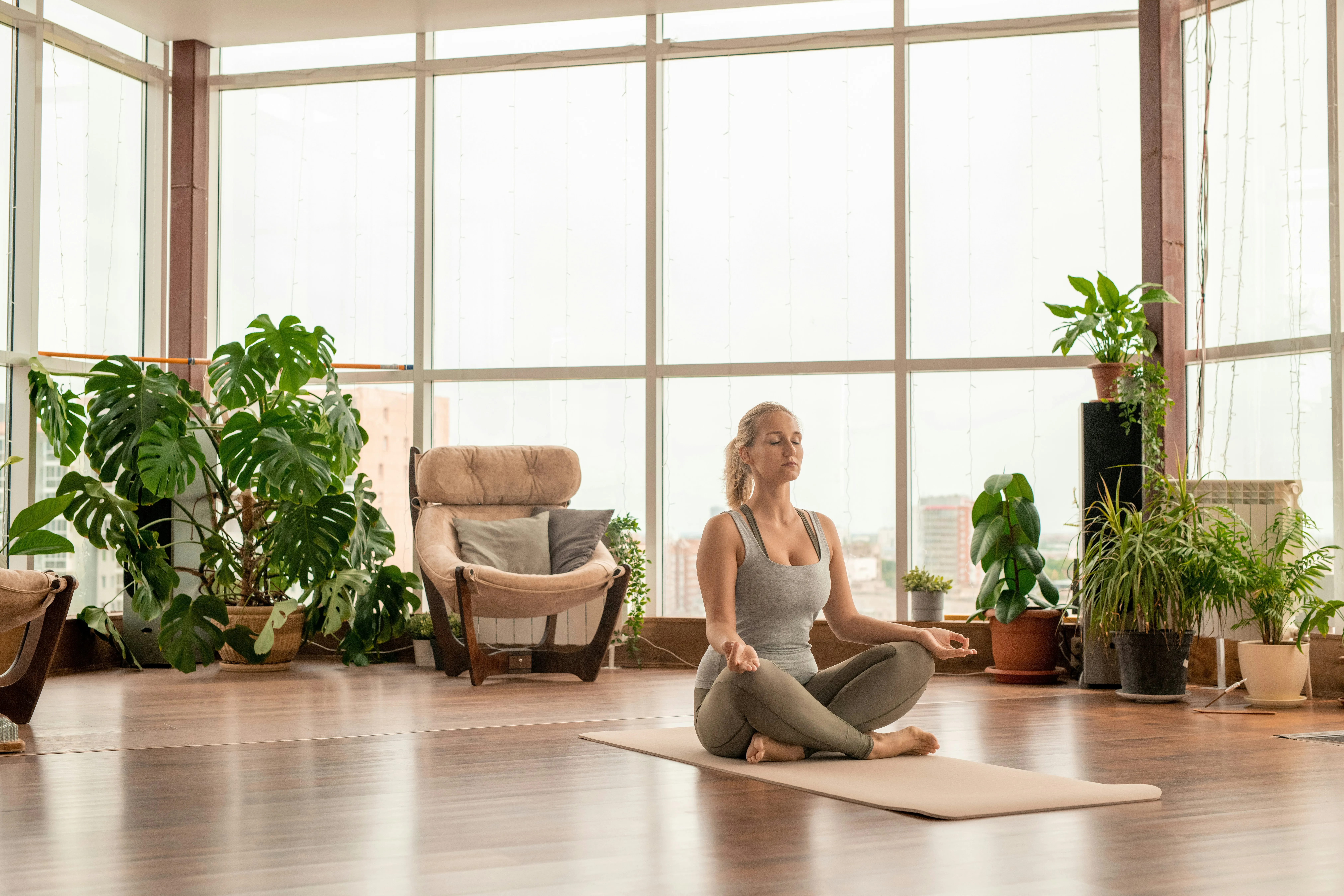Woman meditating with eyes closed in a bright loft space, practicing box breathing