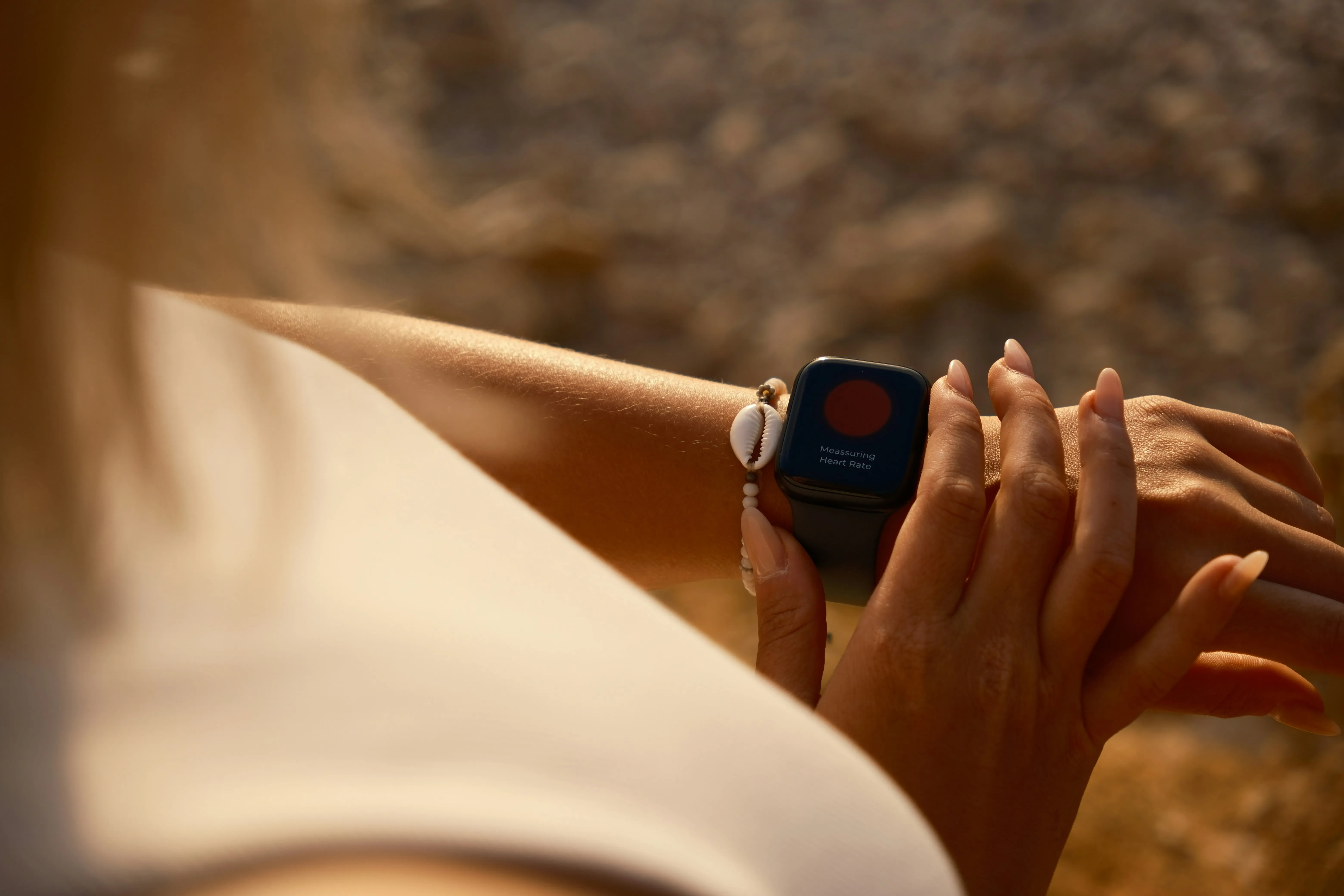 Close-up of a smartwatch outdoors displaying heart rate variability and health metrics