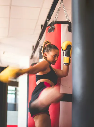 Woman punching a heavy bag with boxing gloves