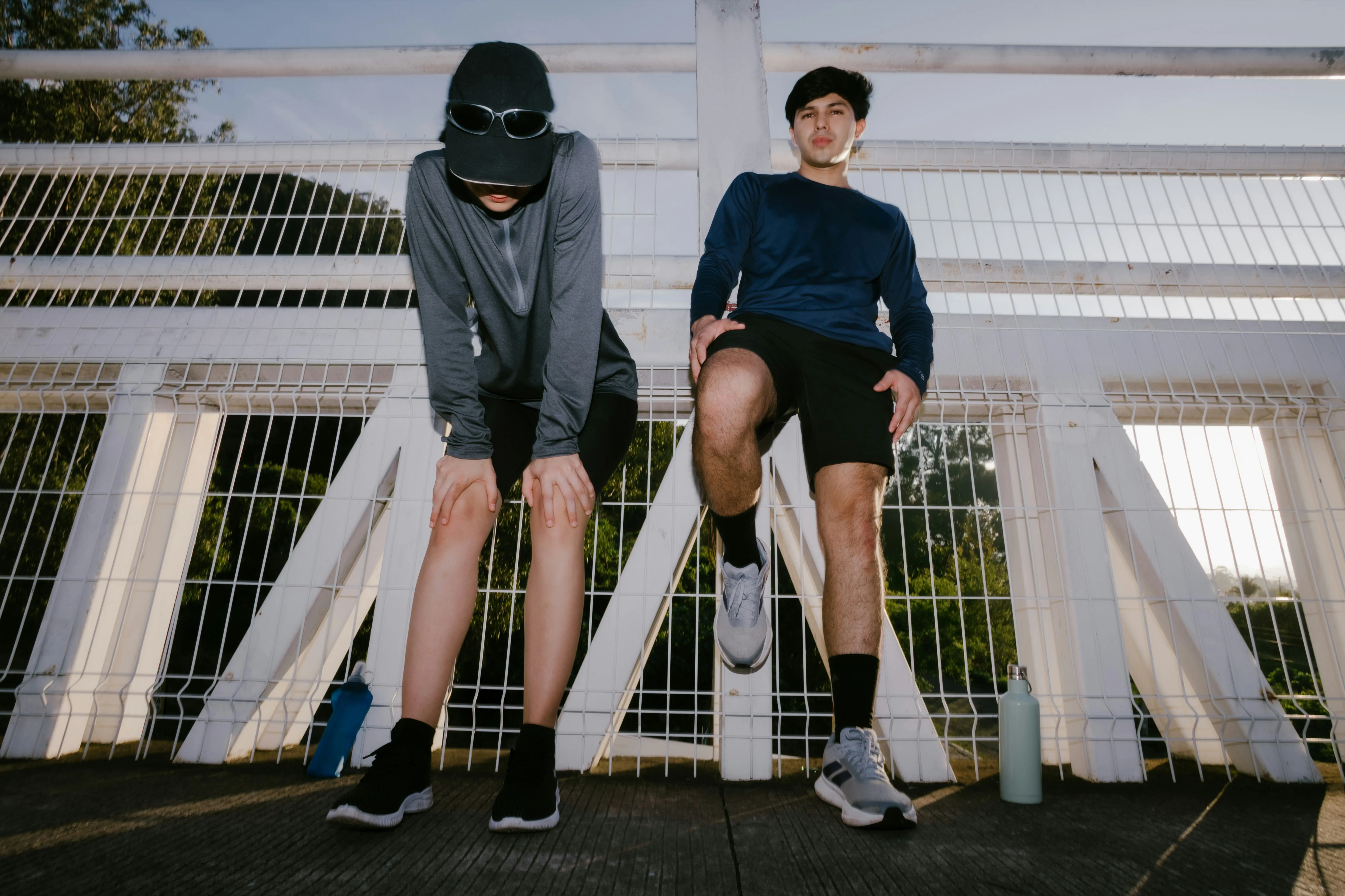 Two men resting after an intense workout, showing signs of fatigue from heavy training