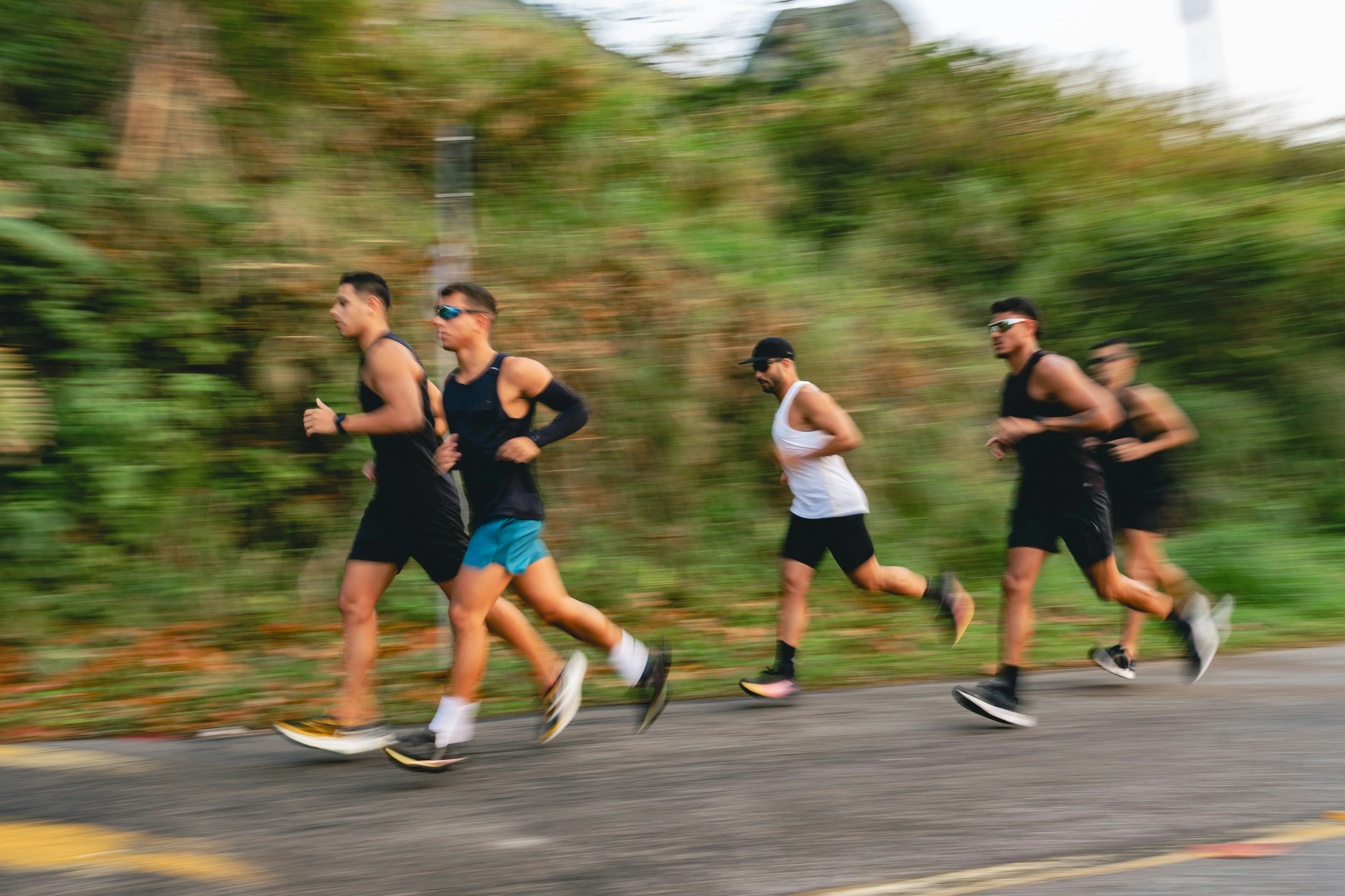Four men running with motion blur, capturing the intensity of a high training load session