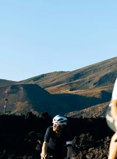 Cyclists riding through volcanic landscape
