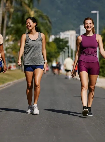 Three women walking together on a sunny outdoor path